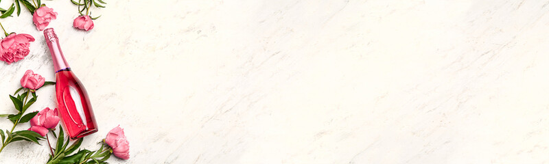 Bottle of champagne and flowers on light background with space for text © Pixel-Shot