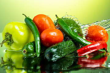 set of vegetables for salad with water splashes on gradient background
