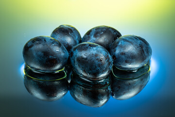 plum or prune on water surface with splash and color reflection