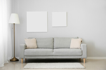 Blank posters with sofa and lamp in interior of modern living room