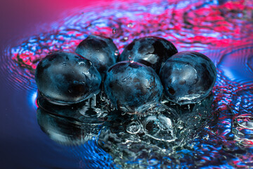 plum or prune on water surface with splash and color reflection