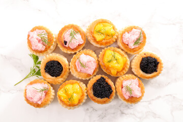 festive canape, buffet food- puff pastry with caviar, salmon and seafood cream