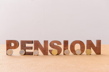 Word PENSION with coins on table