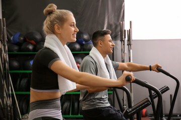 Young people training on exercising bike in gym