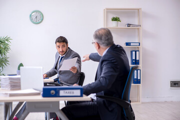 Old boss and his young assistant working in the office