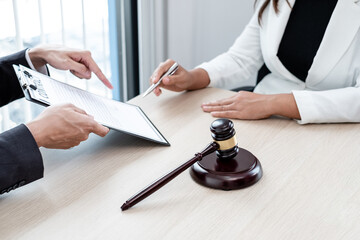 A male lawyer or a judge counseling clients about judicial justice and prosecution with scales, judges gavel, legal documents legal services concept