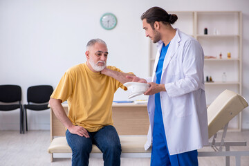 Old neck injured man visiting young male doctor