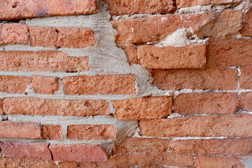 Obraz premium Old red brick wall as texture. Close-up view of the brickwork with different shape bricks. Building, texture pattern, background for the design