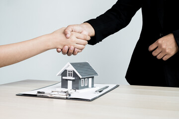 Fototapeta na wymiar Businessmen and brokers real estate agents shake hands after completing negotiations to buy houses insurance and sign contracts. Home insurance concept