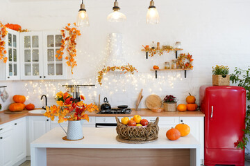Autumn kitchen interior with pumpkins and falling leaves. Thanksgiving dinner and autumn decoration.