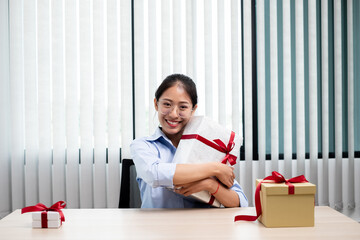 Asian woman holding a gift box Glad to be the giver of surprise with excitement, joy and smiles on...