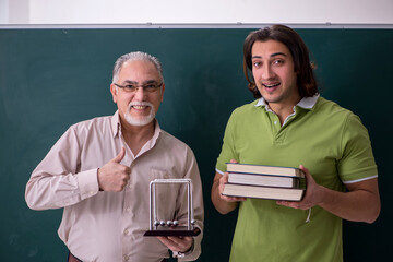 Old professor physicist and young student in the classroom