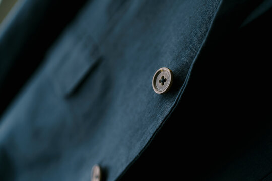 Close-up Of A Brown Button On A Navy Blue Men's Blazer.