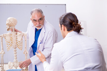 Fototapeta premium Experienced doctor surgeon teaching young male assistant