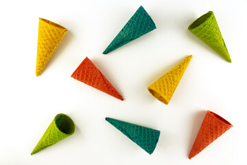 Set of various bright multicolored ice-cream waffle cones on white background .