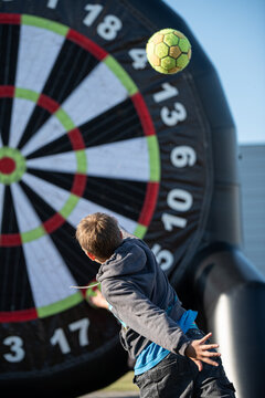 Boy throwing a soccer ball to huge dartboard