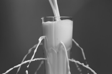 milk flows out of the holes in the glass Cup
