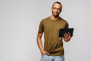 Portrait of a young african american man wearing green t-shirt holding tablet pc pad