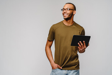 Portrait of a young african american man wearing green t-shirt holding tablet pc pad