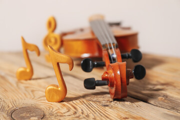Violin with music notes on table, closeup