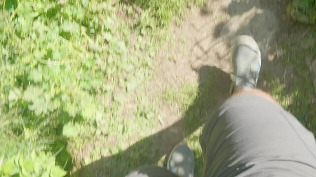 Up view of legs in sportshoes walking on bridge hanging over the river Mahar with strong flow.