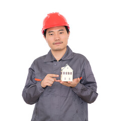 Architect wearing red hard hat viewing small house model in hand