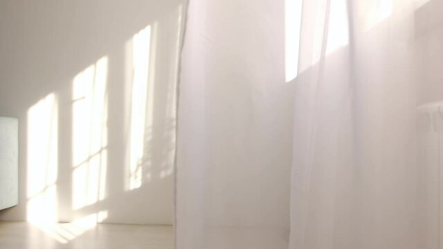 wind blows through the open window in the room. Waving white tulle near the window. Morning sun lighting the room, shadow background overlays.