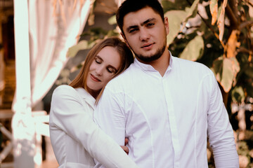 Fototapeta premium a girl in a white suit leans on a man