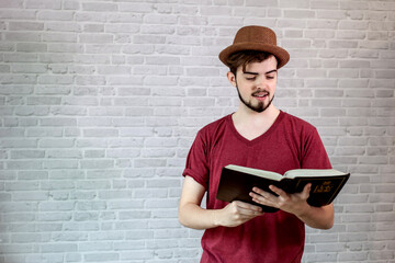 Young man wear a red shirt holding a bible.