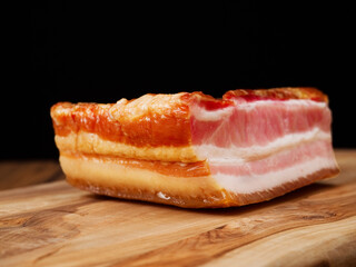 Smoked pork joint on a wooden cutting board. Traditional East European cuisine. Meat industry product.