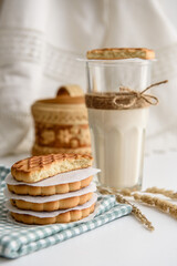 Cookies and a glass of milk close up on a linen napkin on a white background
