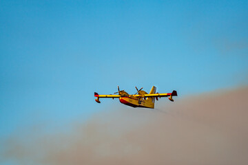 Fototapeta na wymiar Hydroplane flying out of the fire smoke