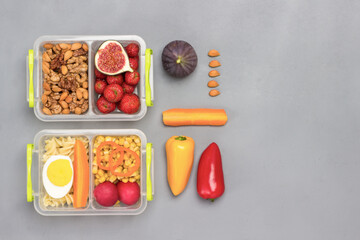 School lunch boxes with tasty food. Colored vegetables on table