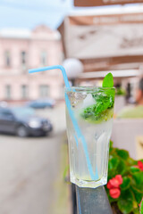 Cold summer fruit and berries lemonade. Mojito lemonade in a glass with a plastic straw outside.