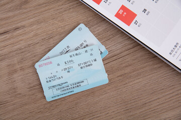 Train ticket and a desk calendar for Spring Festival.The Chinese character on the train ticket means: "Train information and boarding time". Passenger information has been removed from the ticket