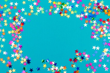colorful stars confetti and copy space isolated on blue background