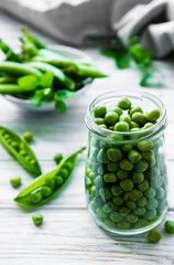 Healthy food. Fresh green peas in open glass jar  on wooden background