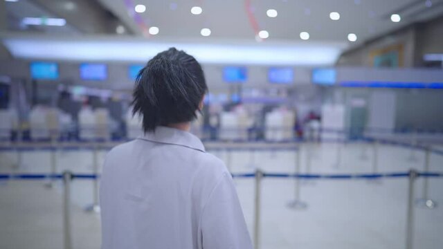 Asian woman wear protective mask looking for her flight check-in counter, covid-19 pandemic new normal, late for flight mistaken for airlines boarding time, empty airport terminal, slow motion