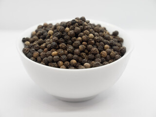 Black pepper, herbs, spices in a white bowl