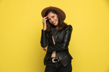 shy woman in leather jacket arranging hair