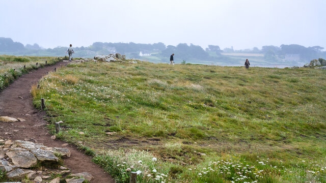 PLOUGRESCANT, FRANCE - JULY 2, 2010: path in green moorland on coast of Gouffre gulf of English Channel near Plougrescant town of the Cotes-d'Armor department in Brittany in summer rany day