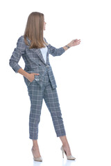 young woman holding hand in pocket and presenting to side