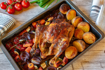 italian roast chicken with oven baked vegetables on a baking tray