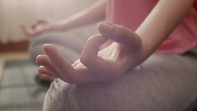 Close up Hand of woman doing yoga exercises with lotus on yoga mat at home