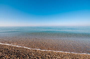 Morning seascape. Dawn haze over a calm sea wave. Carefree ocean background