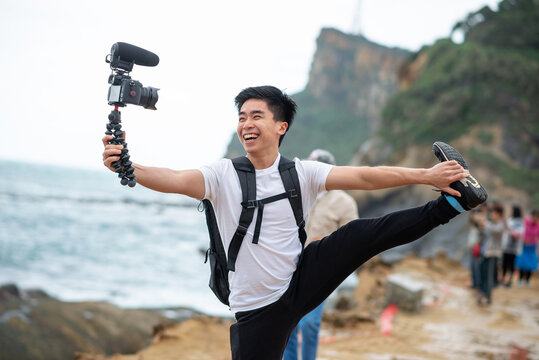 Vlogger holds and smile with his camera