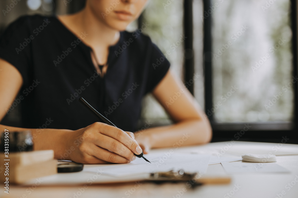 Wall mural female calligrapher working. people and art concept.