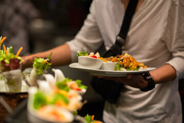 People choosing food from buffet line