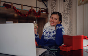 Smiling woman using computer for video call friends and parents.