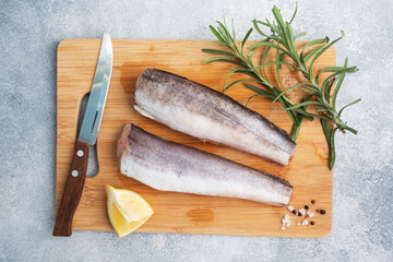 Raw hake fish carcass on a wooden chopping Board. top view Copy space